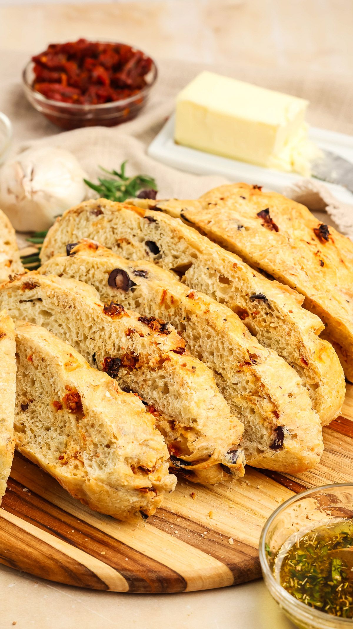 Artesian Italian Bread on a wooden cutting board ready to be served with dipping oil or butter.
