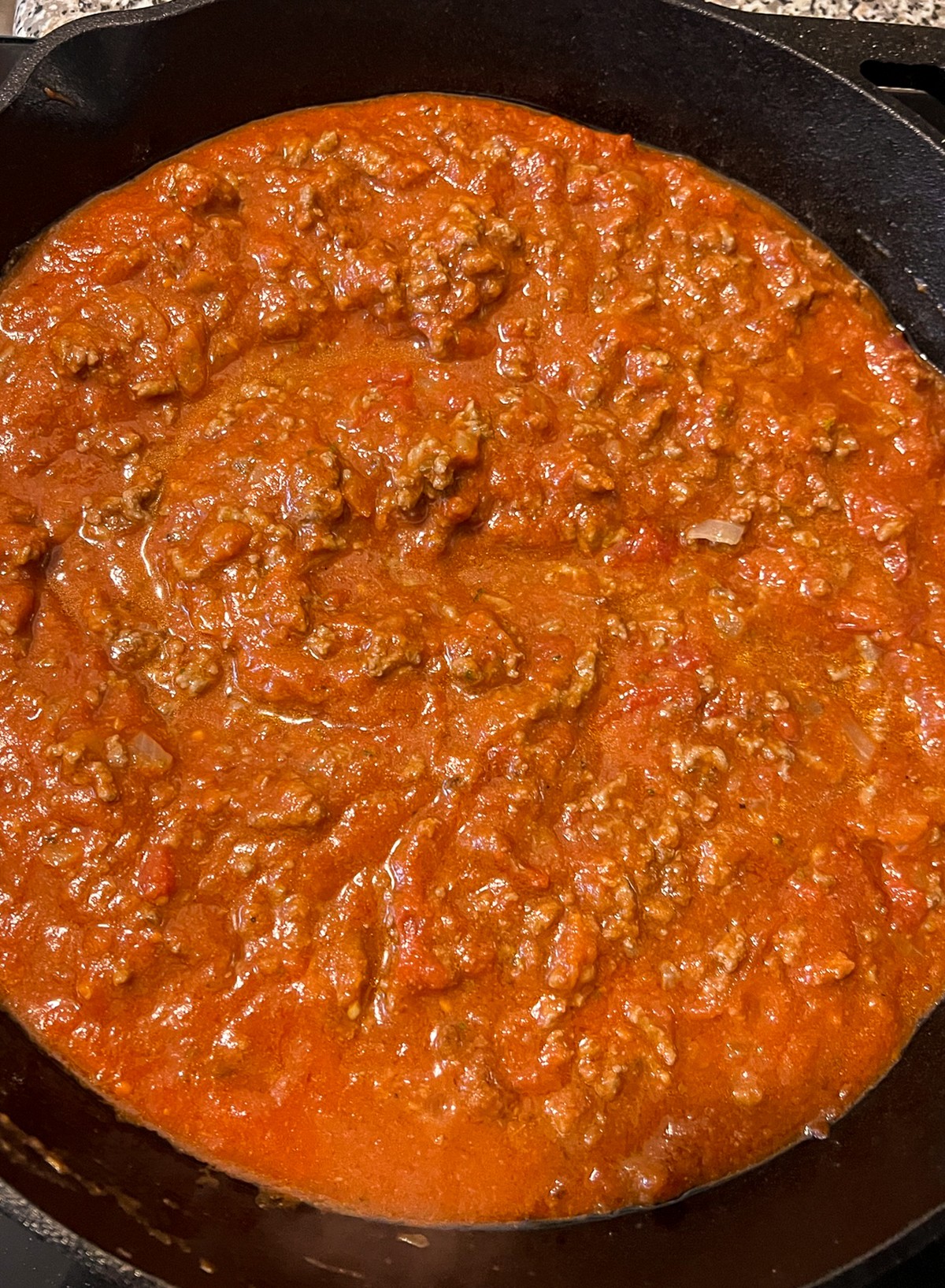 Pasta sauce has been added to the now cooked ground beef.