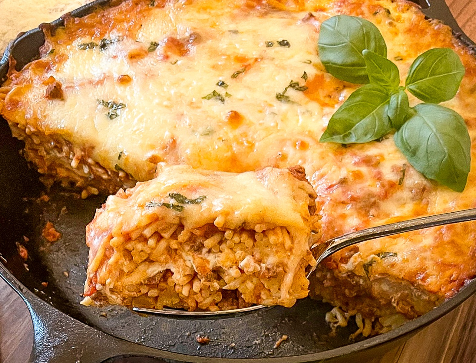 A close up side shot of a slice of pasta showing the layers of cheese, sauce, and noodles.