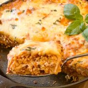 A close up side shot of a slice of Baked Spaghetti Casserole showing the layers of cheese, sauce, and pasta.