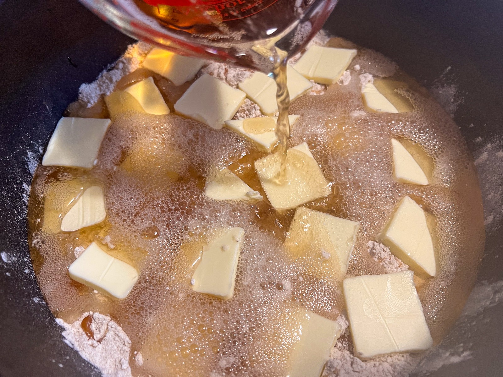 Cream soda being poured over the cake.