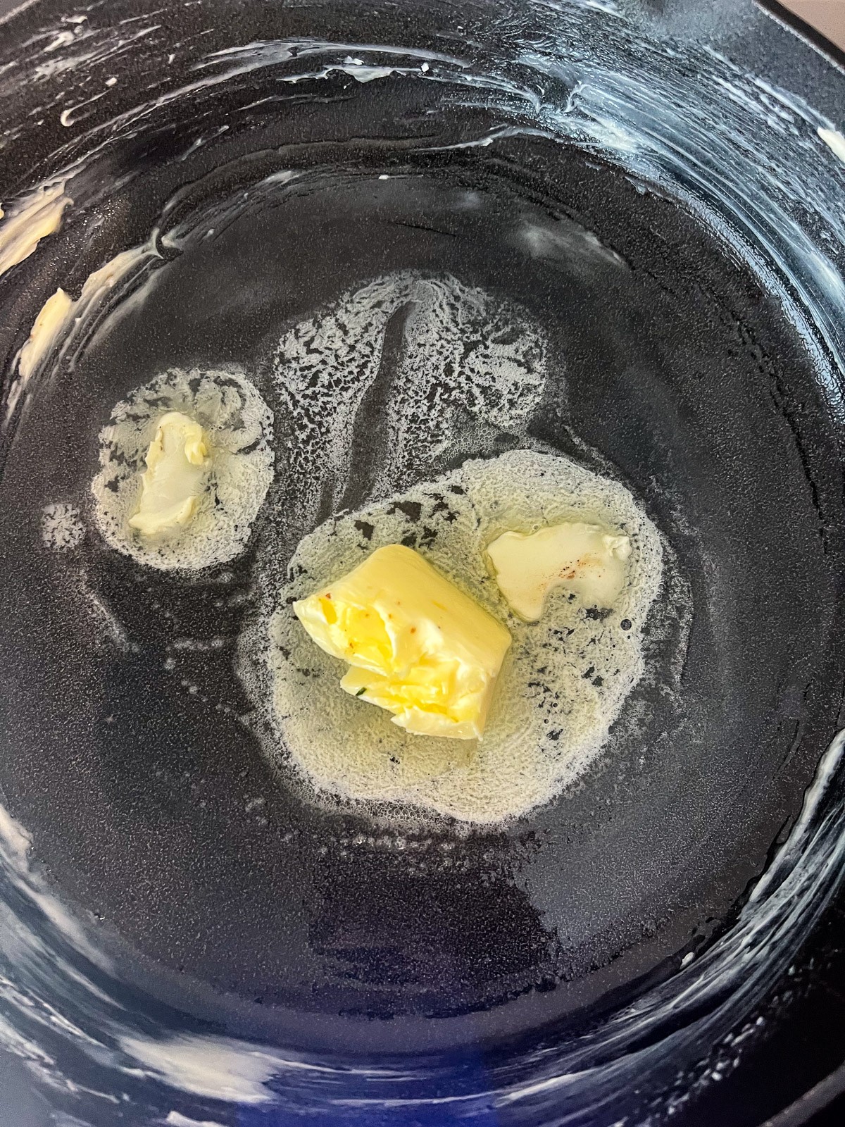 Butter melting in a cast iron pan or skillet.