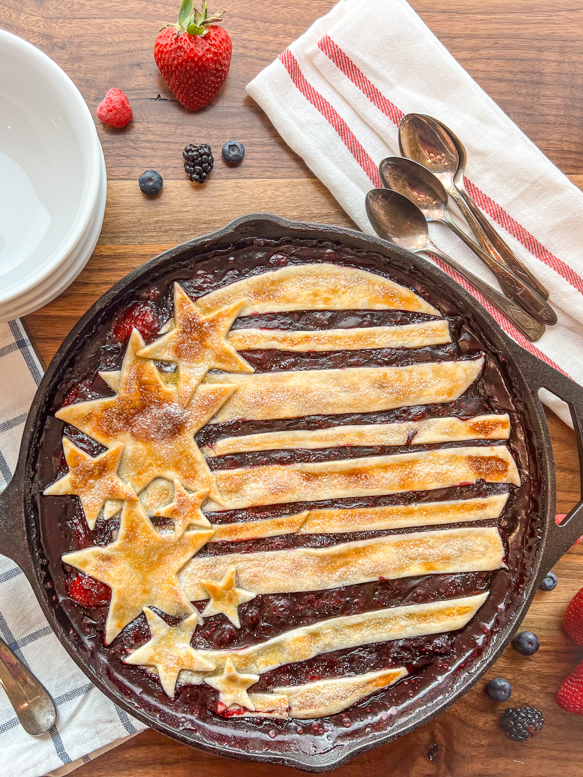 Baked cast iron skillet berry cobbler with golden pie crust and bubbling berry filling
