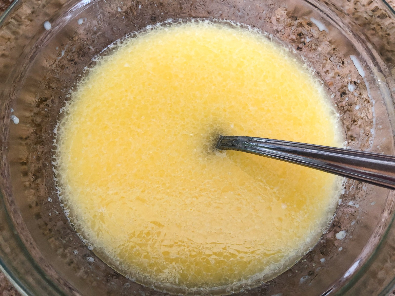The eggs, butter, milk, and oil combined in one bowl.