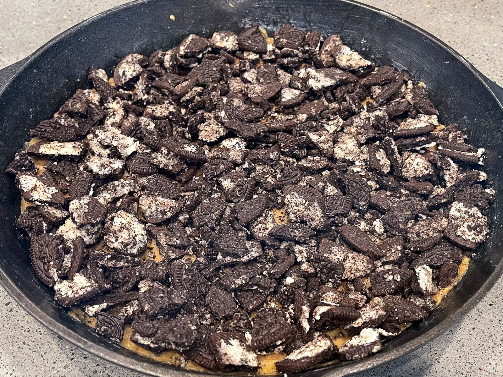 Chocolate fudge brownie mix poured over the bare metal skillet mixture.