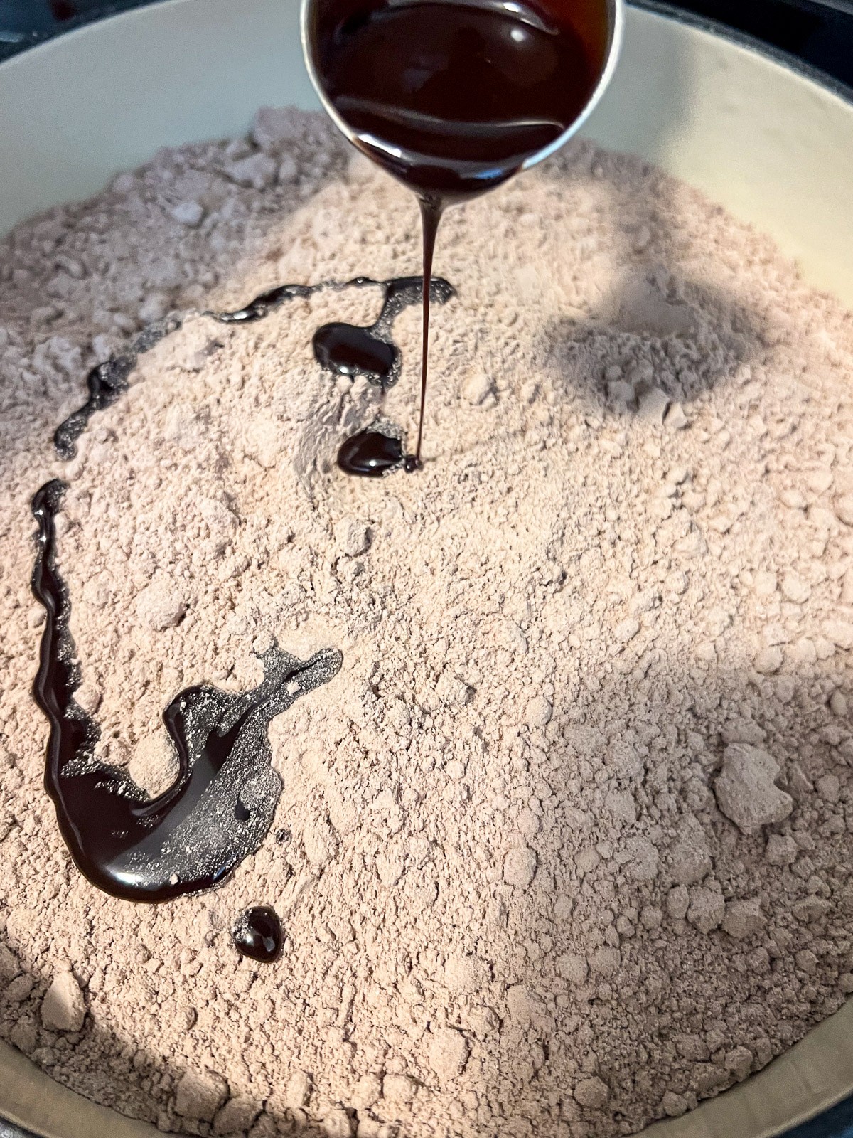 Chocolate syrup has been drizzled over the dry cake mix.