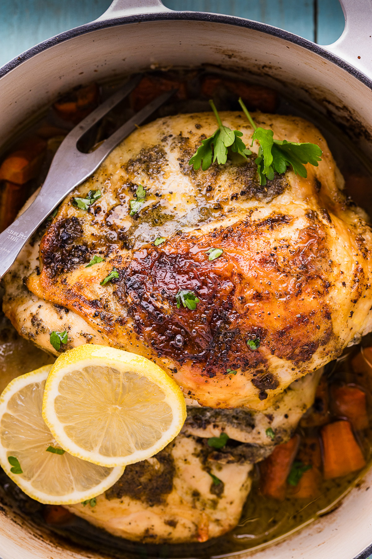 Dutch oven chicken recipe with golden lemon herb butter chicken breasts roasted over carrots and onions