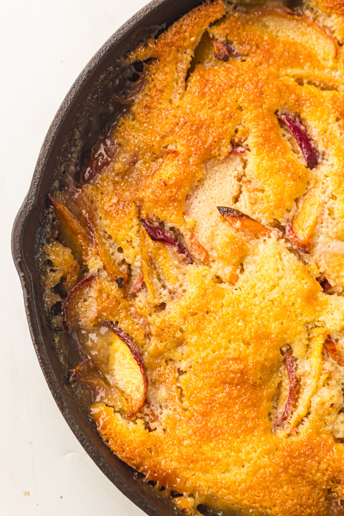 Dutch Oven peach cobbler ready to be scooped out of the cast iron.
