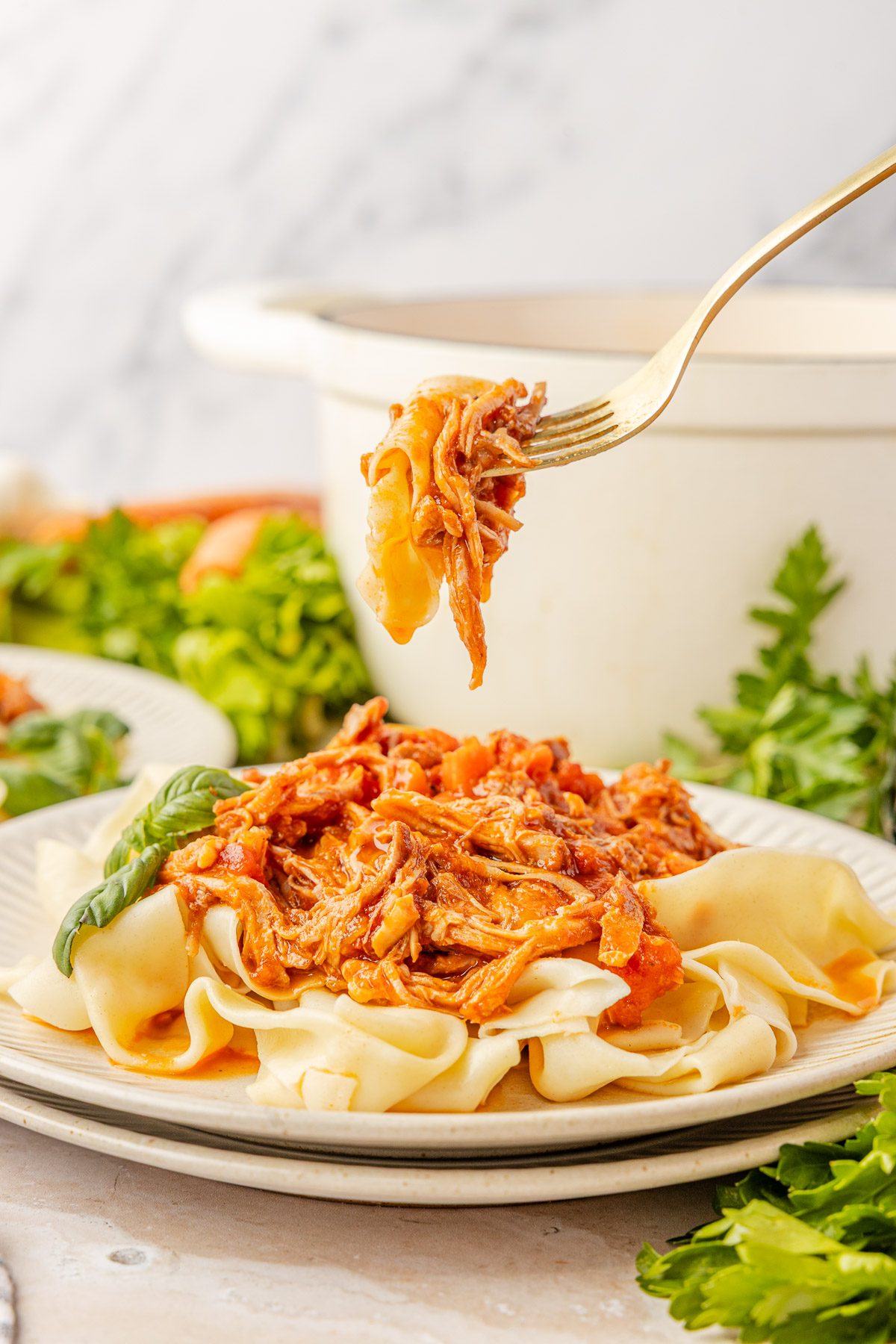 A fork holding some pork ragu in the air.