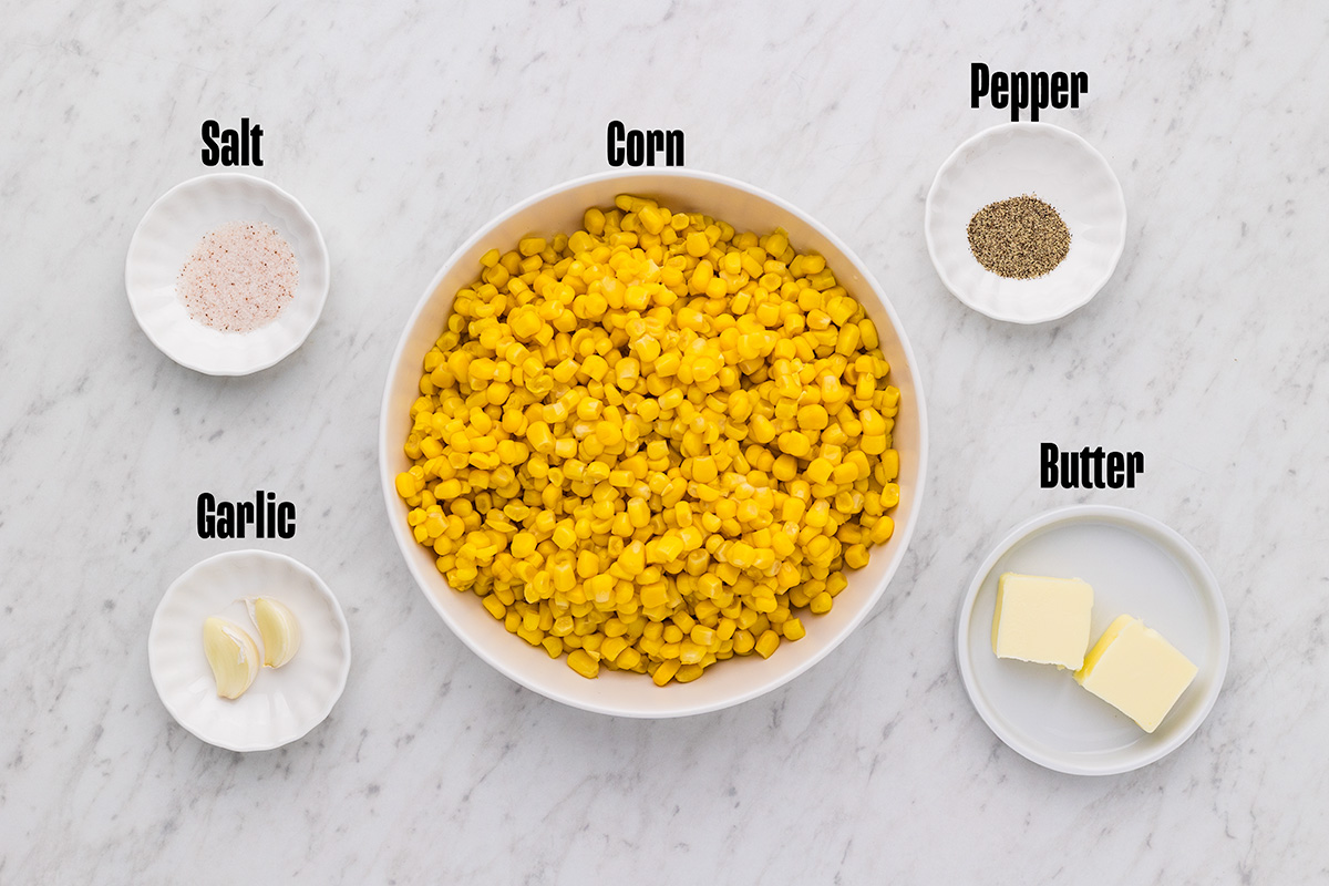 Ingredients for garlic butter skillet corn: canned corn, butter, garlic cloves, salt, and pepper