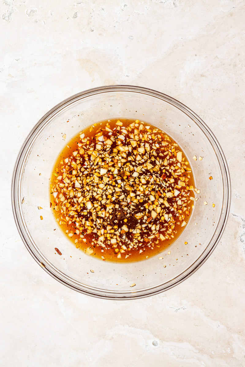 Honey, soy sauce, chicken stock, garlic, and red pepper flakes in a bowl..