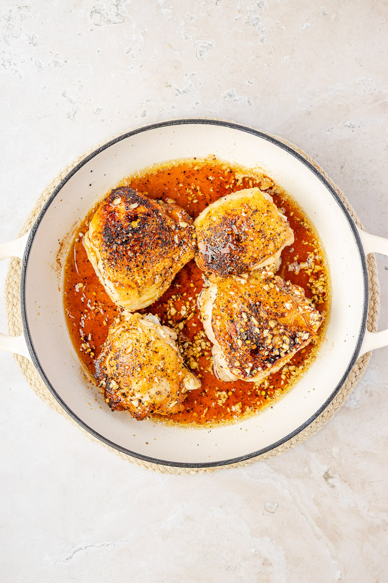 The honey garlic sauce poured over the chicken thighs.