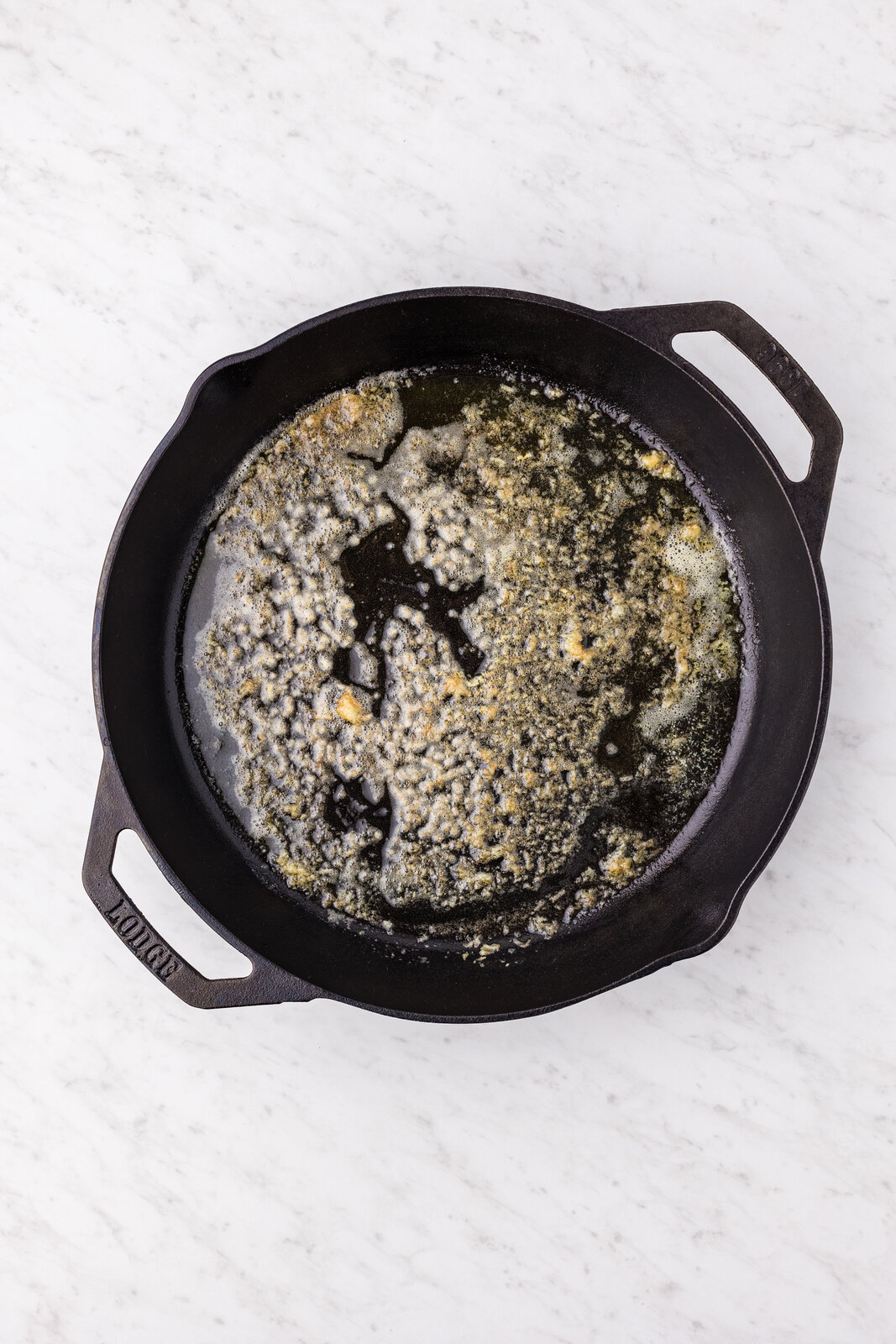 Butter browning with minced garlic in a cast iron skillet