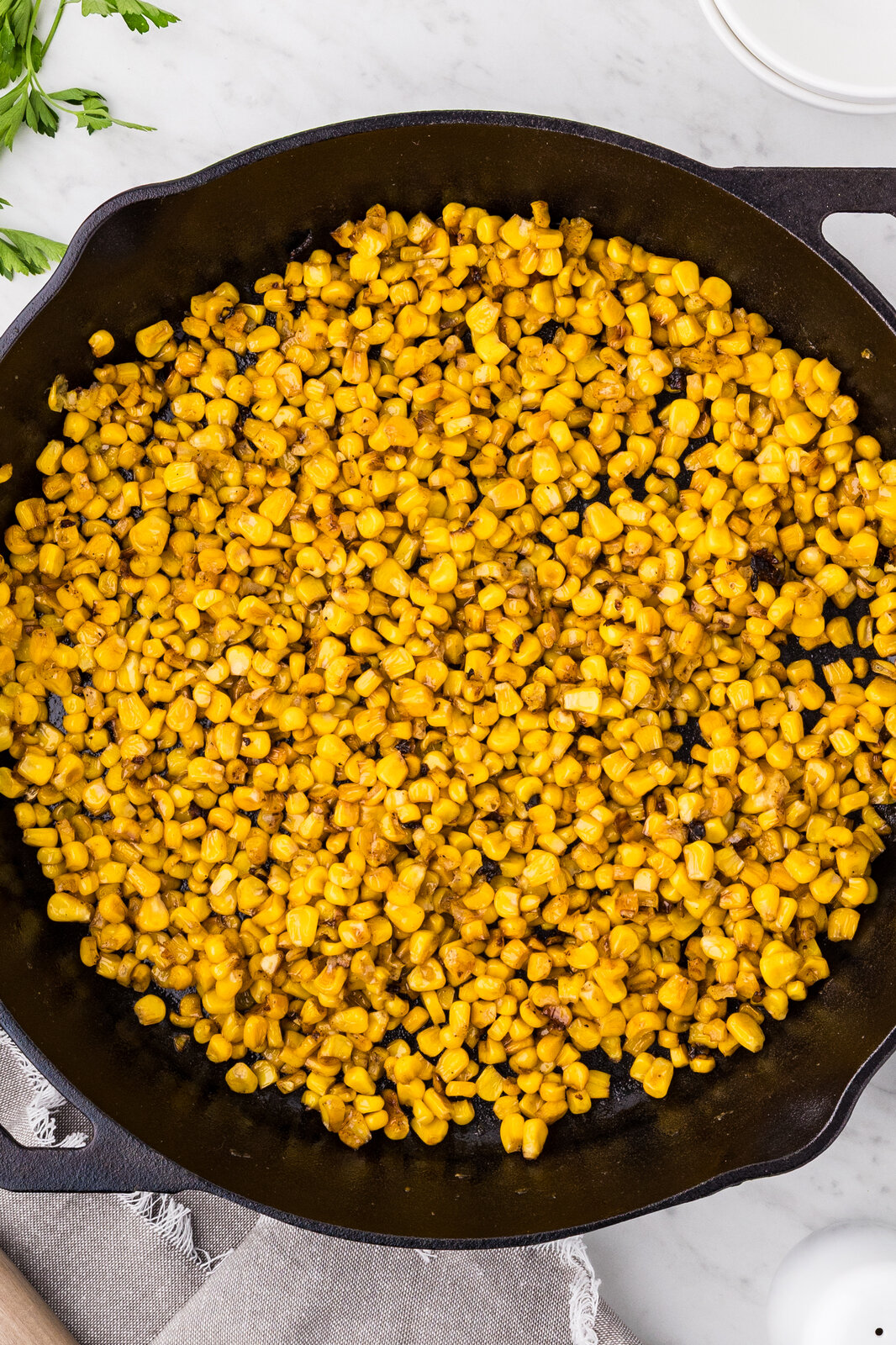 Finished garlic butter skillet corn in a cast iron skillet overhead view