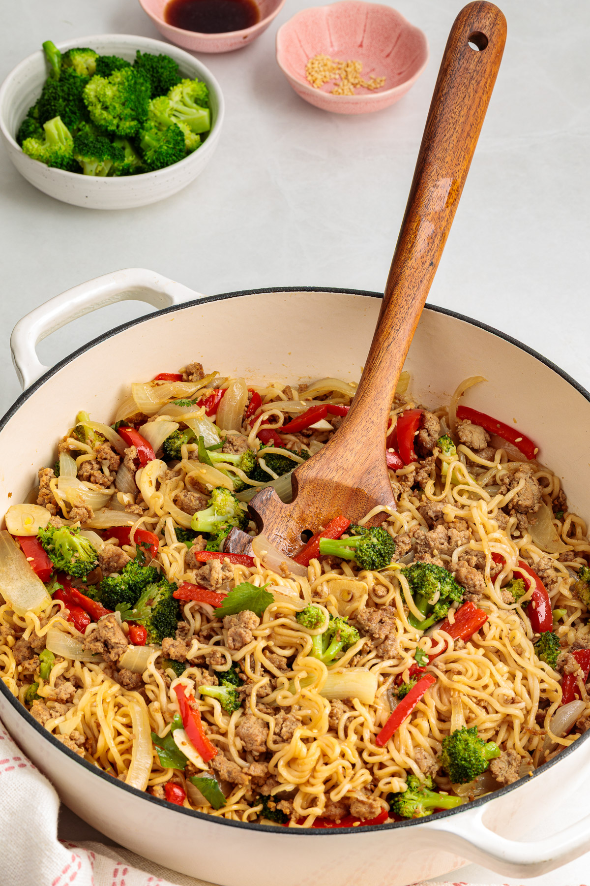 A wooden spoon in a pot of ground turkey stir fry.