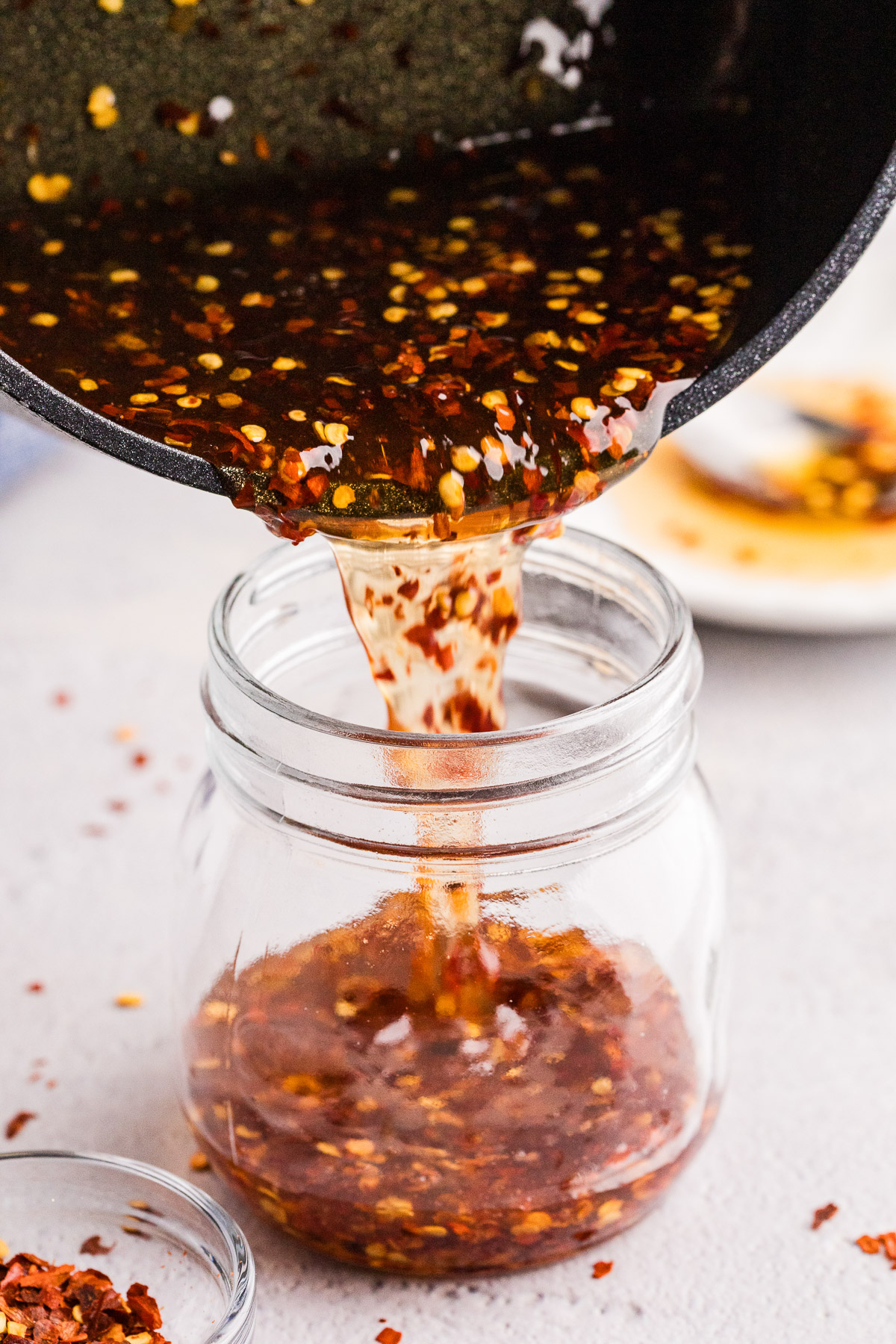 pouring the finished hot honey into the glass jar