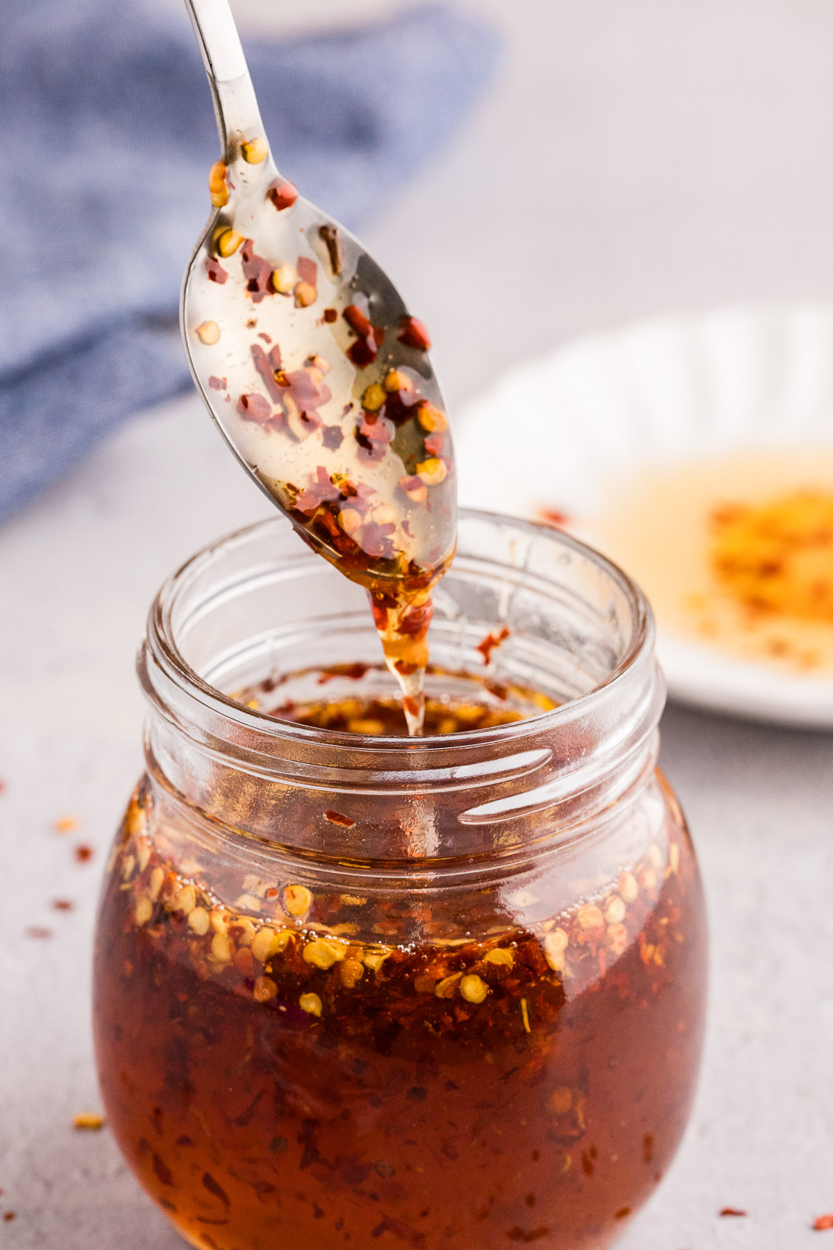 Hot honey recipe in a glass jar with red pepper flakes and thyme visible