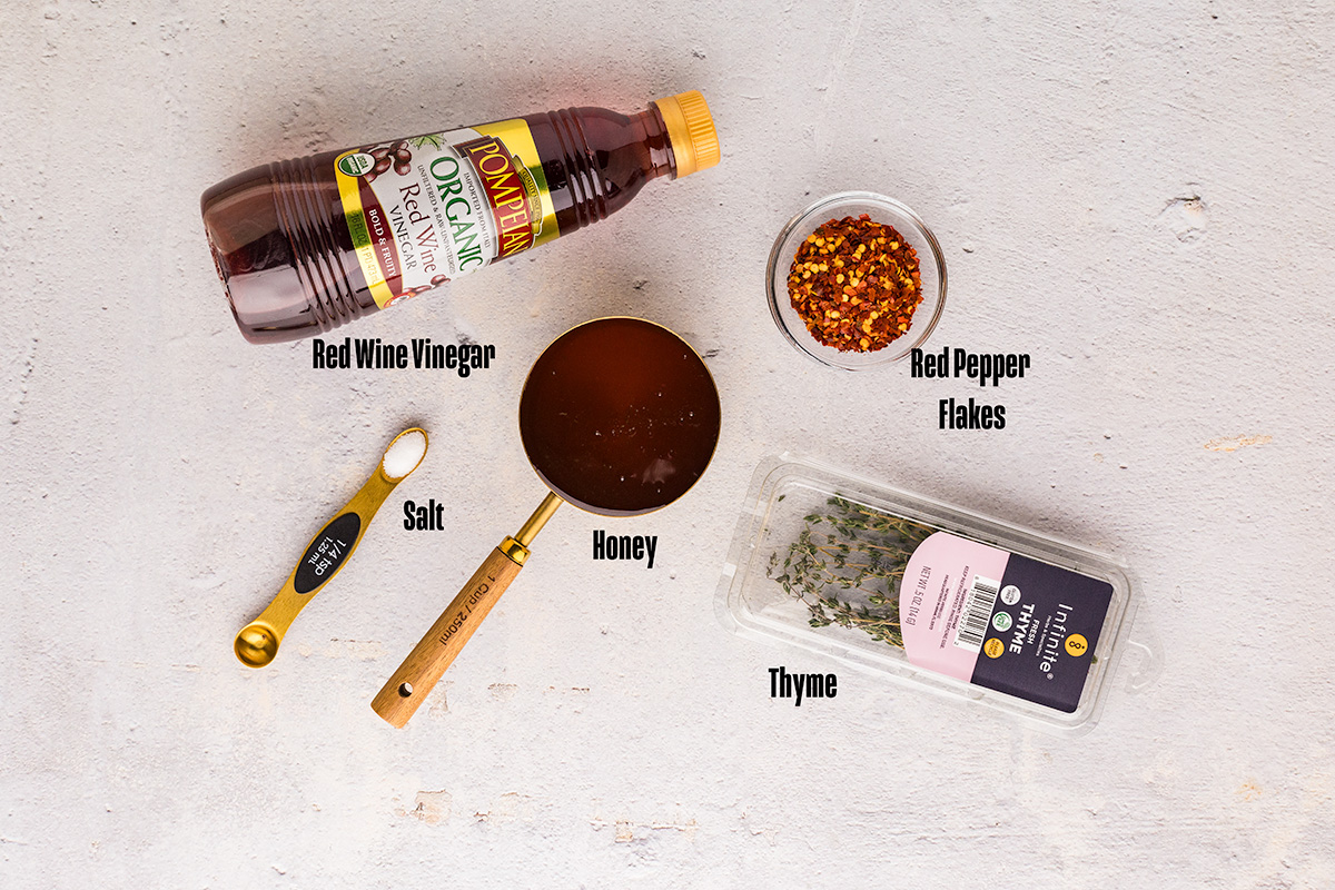 Ingredients for hot honey recipe including honey red pepper flakes and fresh thyme