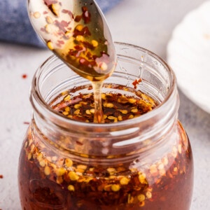 Hot honey drizzled into a glass jar.