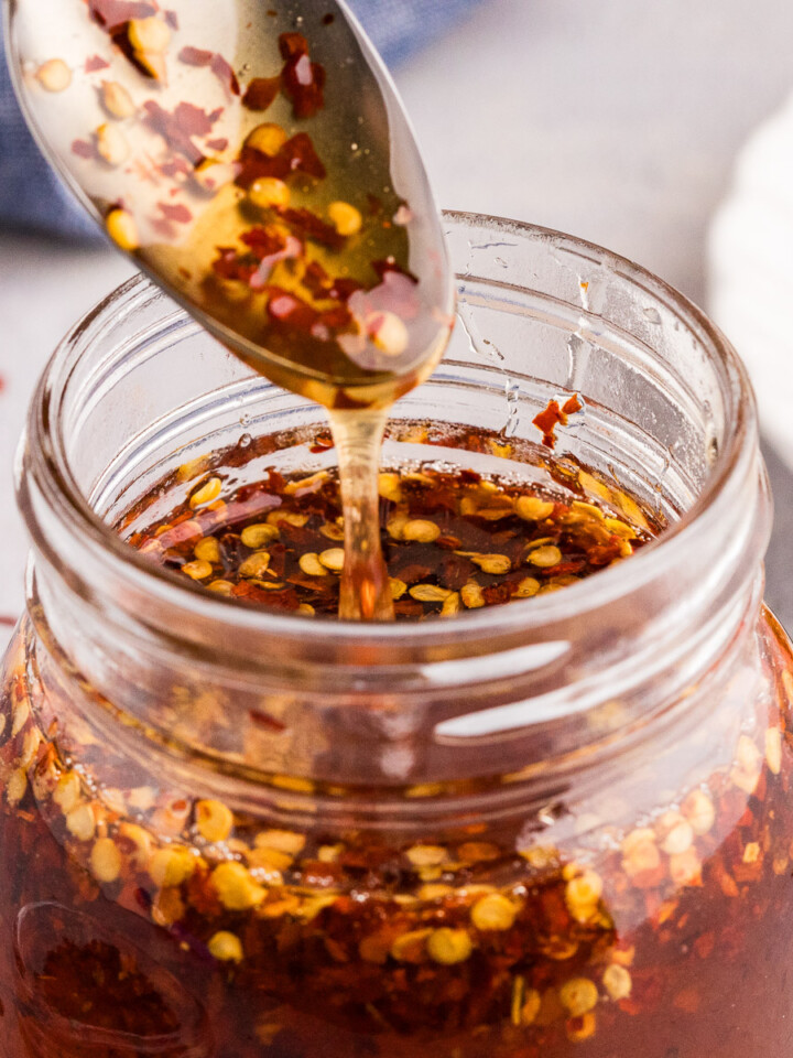 Hot honey drizzled into a glass jar.