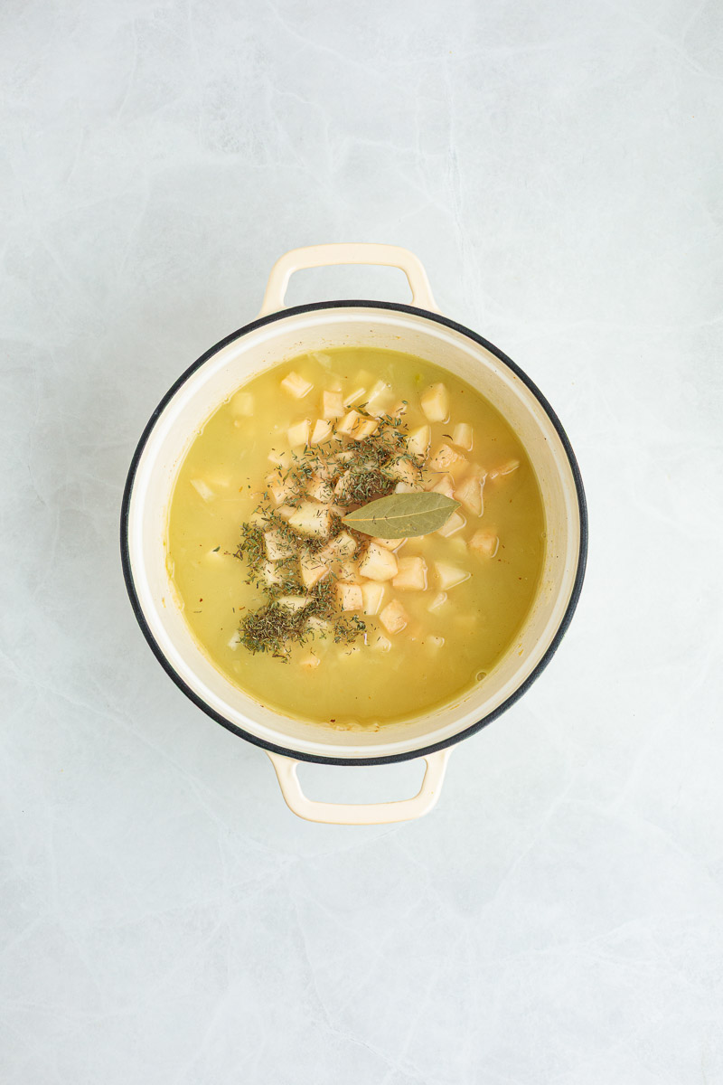 Clam juice, broth, potatoes, bay leaf, and thyme added to the soup.