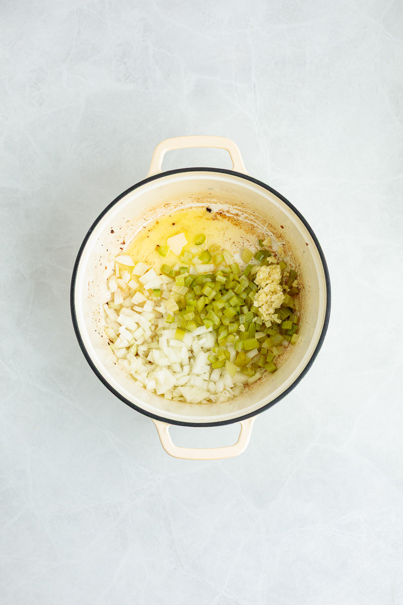 Butter, chopped onion, and celery to the Dutch oven.