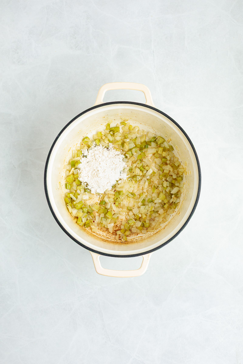 Flour added over the vegetables to form a roux.
