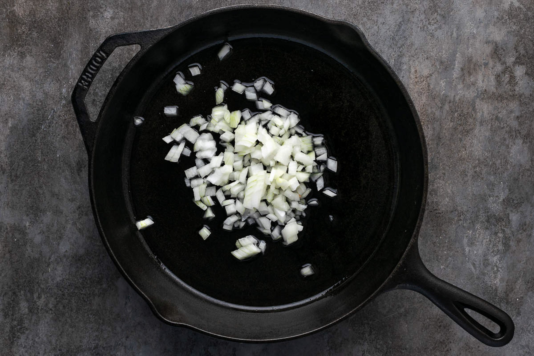 Onions cooking in a cast iron pan.