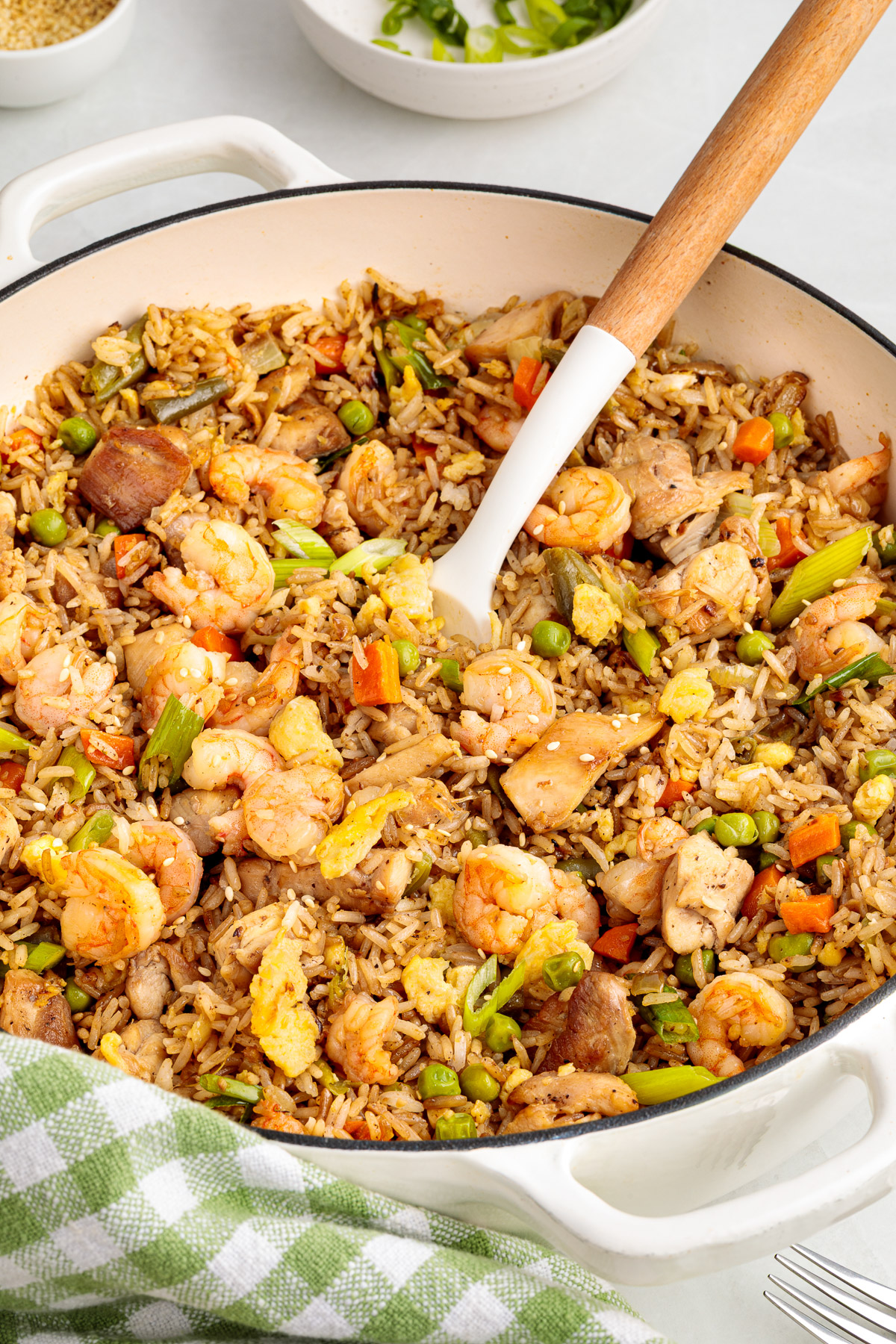 A spoon scooping out some shrimp and chicken fried rice.