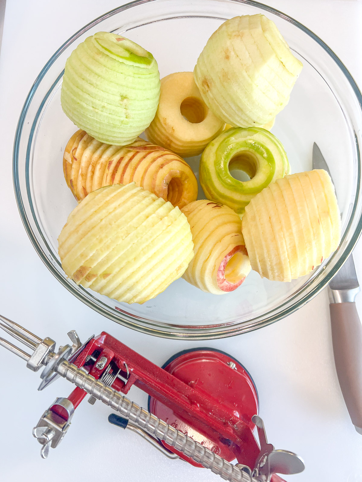 Peeled cored and sliced granny smith and honeycrisp apples in a glass bowl for skillet apple crisp
