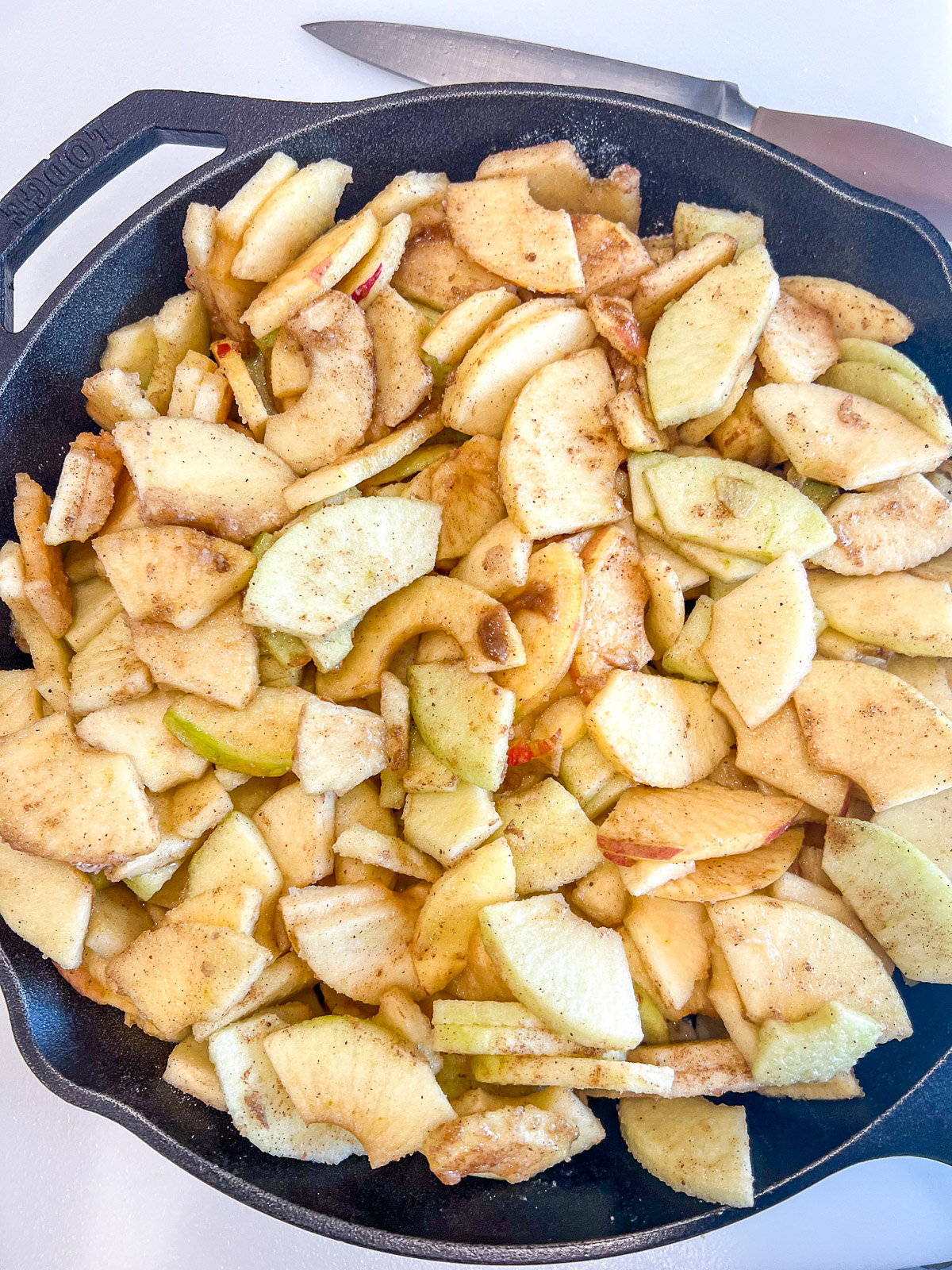 pple pieces coated with flour sugar salt and apple pie spice in a cast iron skillet for skillet apple crisp