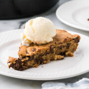 Cookie on a plate served with vanilla ice cream.