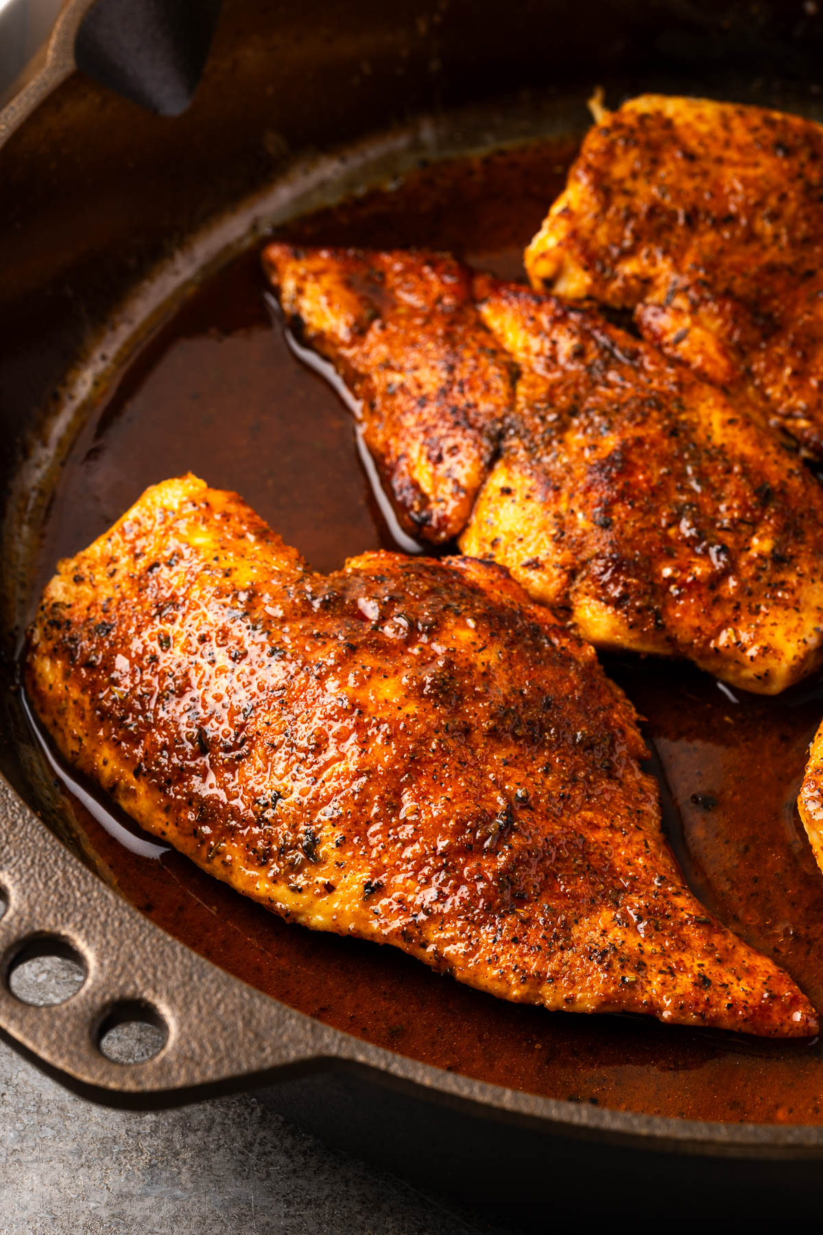 Seared chicken on a cast iron skillet.