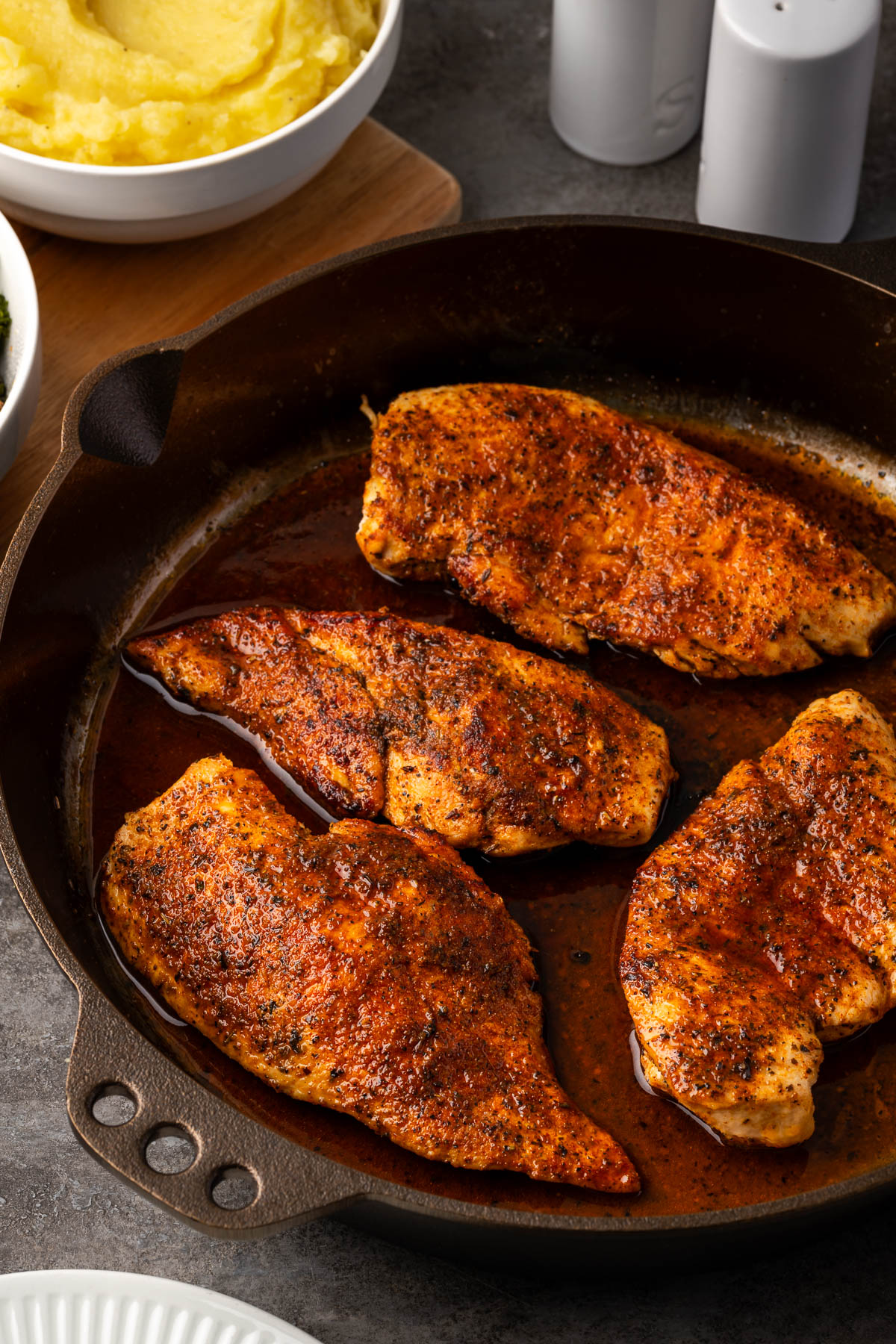Cast iron skillet chicken cooking in a Smithey cast iron skillet.