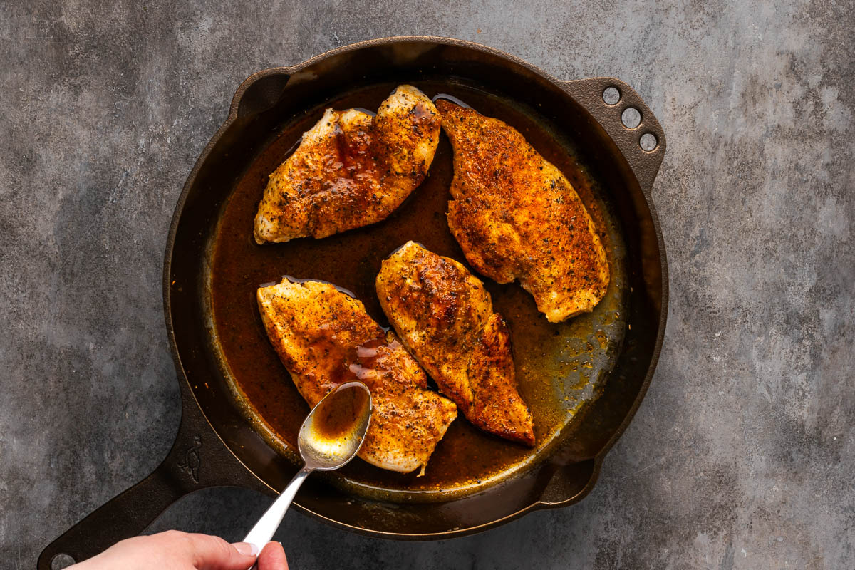 Spooning the butter over the chicken. 