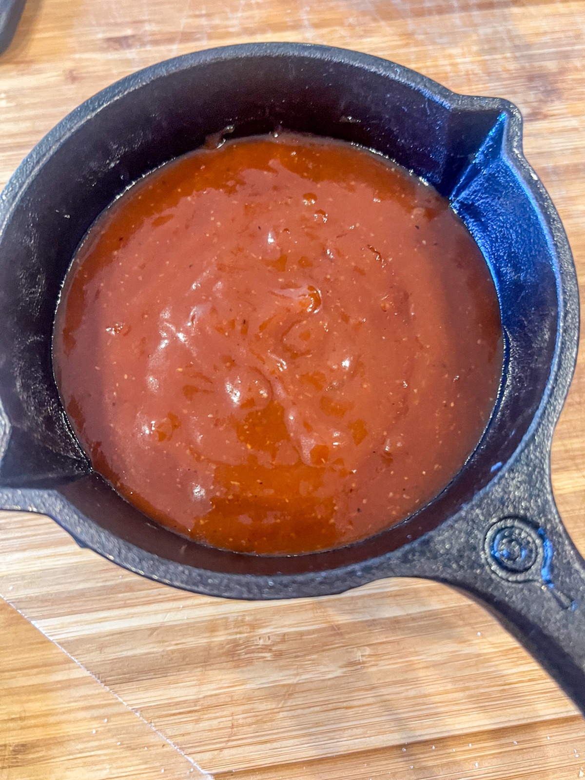 Maple bourbon glaze simmering in a saucepan, thickened and glossy.