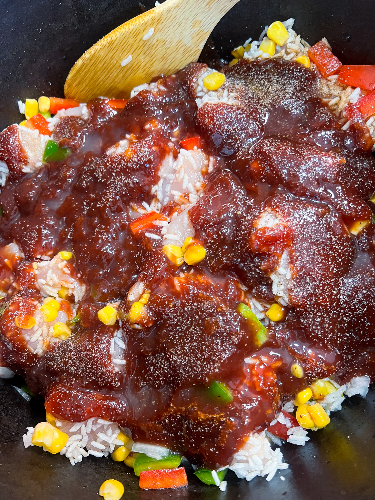Instant rice, frozen corn, bell peppers, onions, and diced chicken combined in a dutch oven
