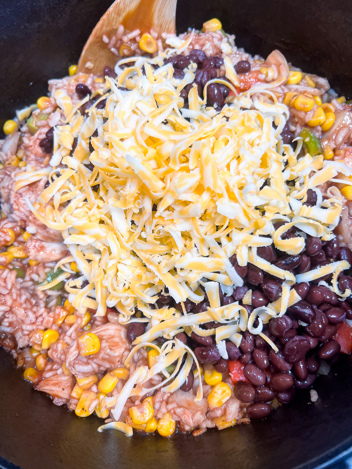 Black beans and colby jack cheese added to the cooked BBQ chicken and rice