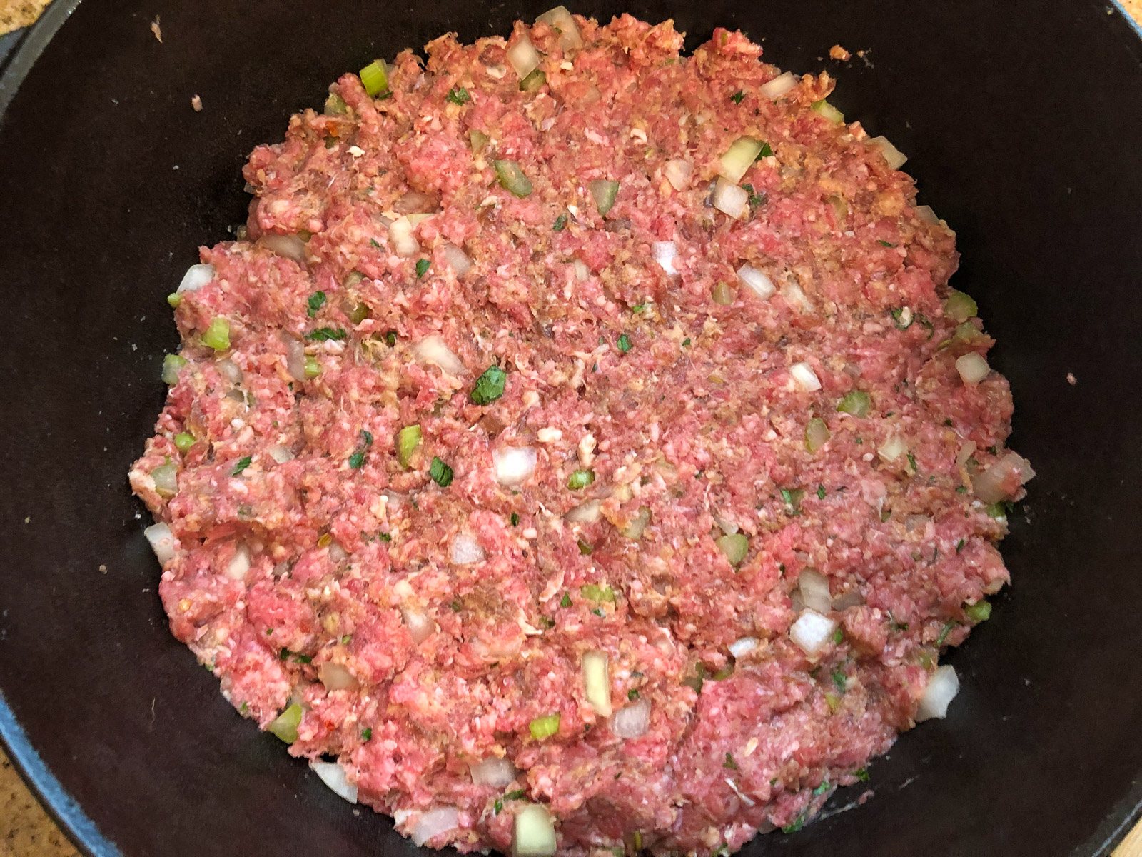 Meatloaf mixture pressed evenly into a Dutch oven
