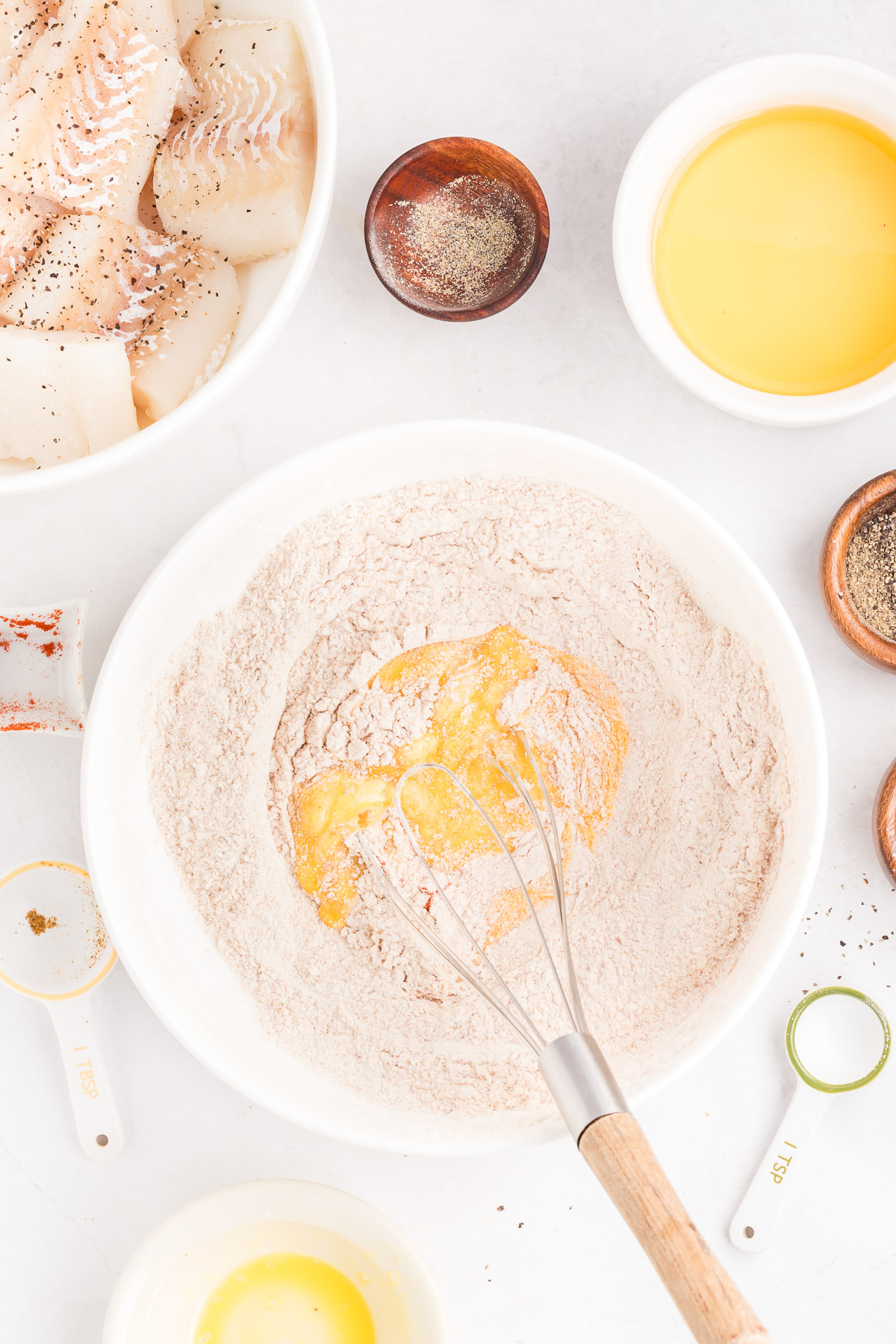 Pouring beer into flour and spice mixture to make beer batter for fish