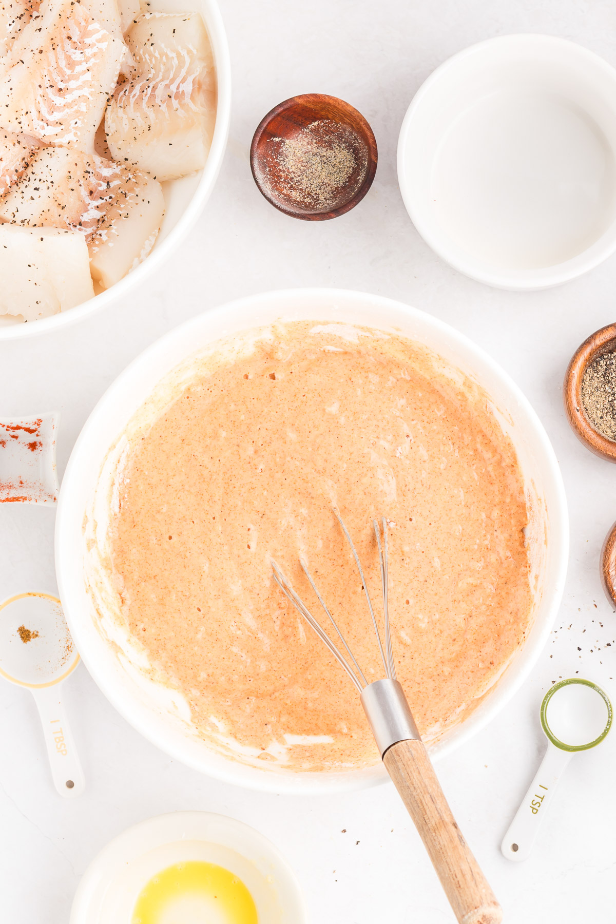 Finished beer batter in a bowl with a whisk, ready for dipping cod
