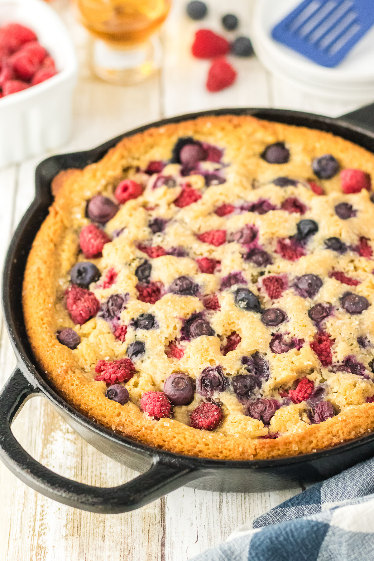Golden brown bourbon berry brown sugar cake fresh from the oven in a cast iron skillet