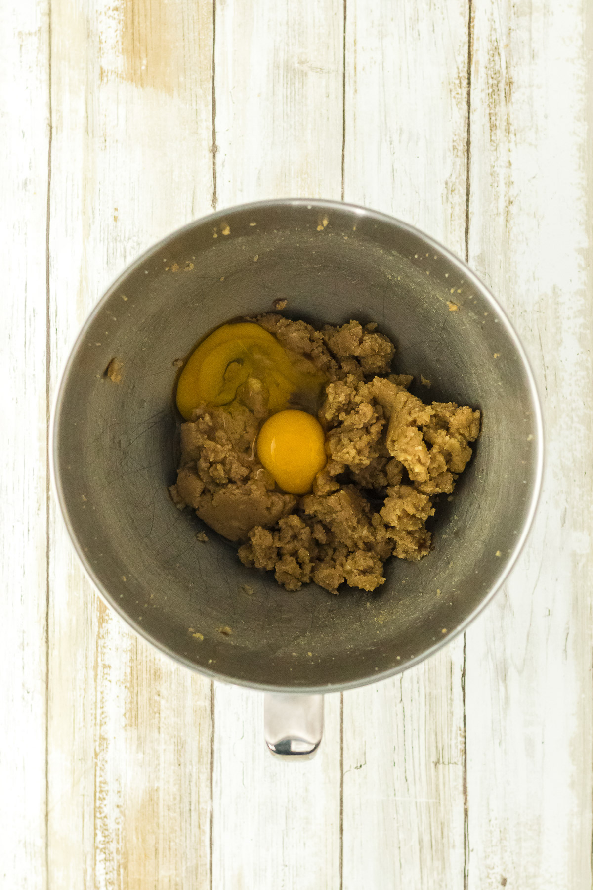 Egg added to creamed butter and sugar mixture in a stand mixer bowl