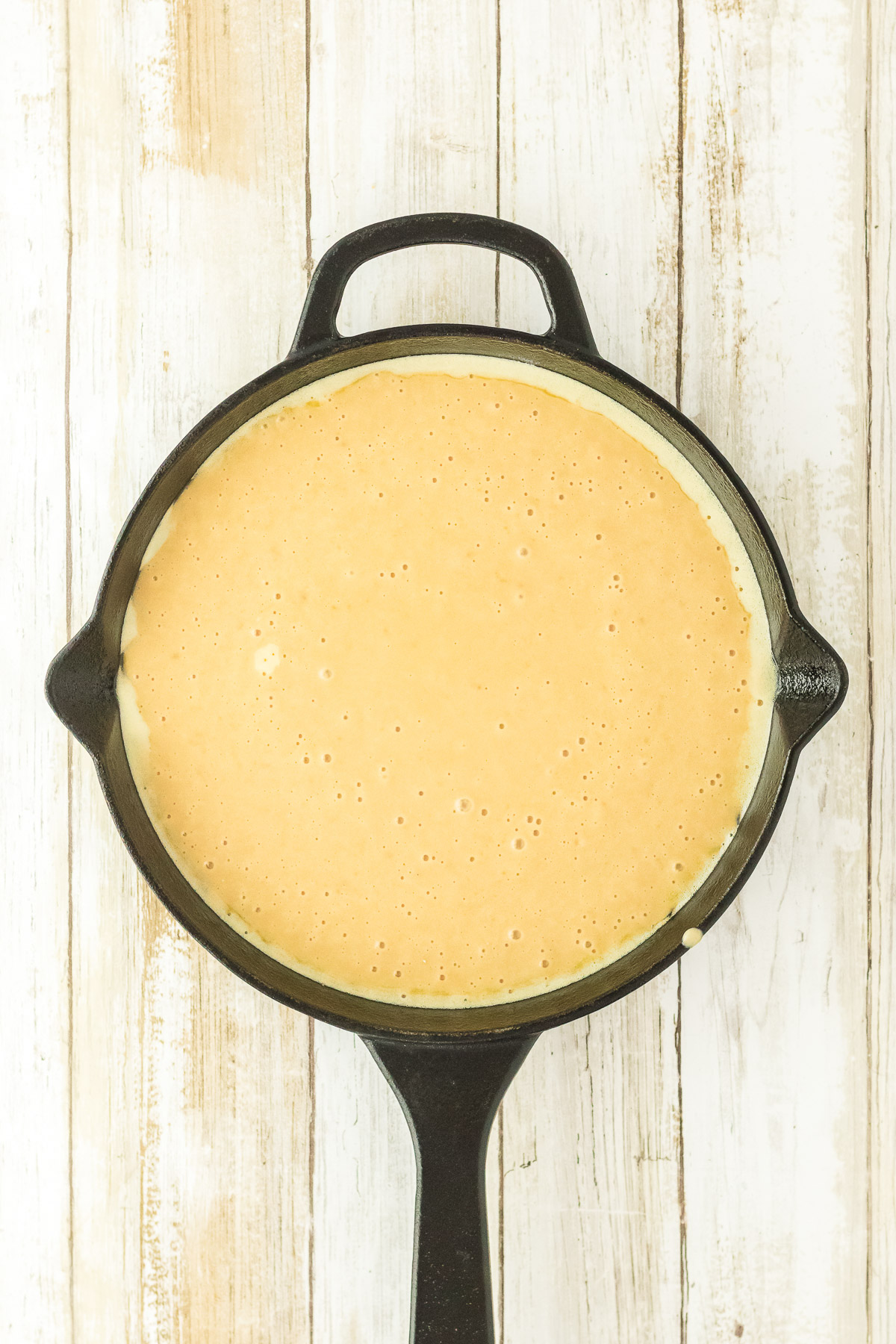 Brown sugar cake batter poured into a greased cast iron skillet