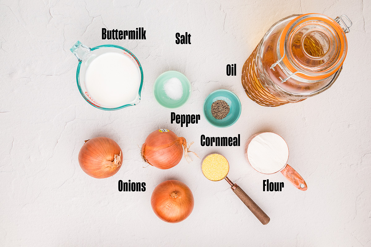 Ingredients laid out: sliced yellow onions, buttermilk, flour, and cornmeal