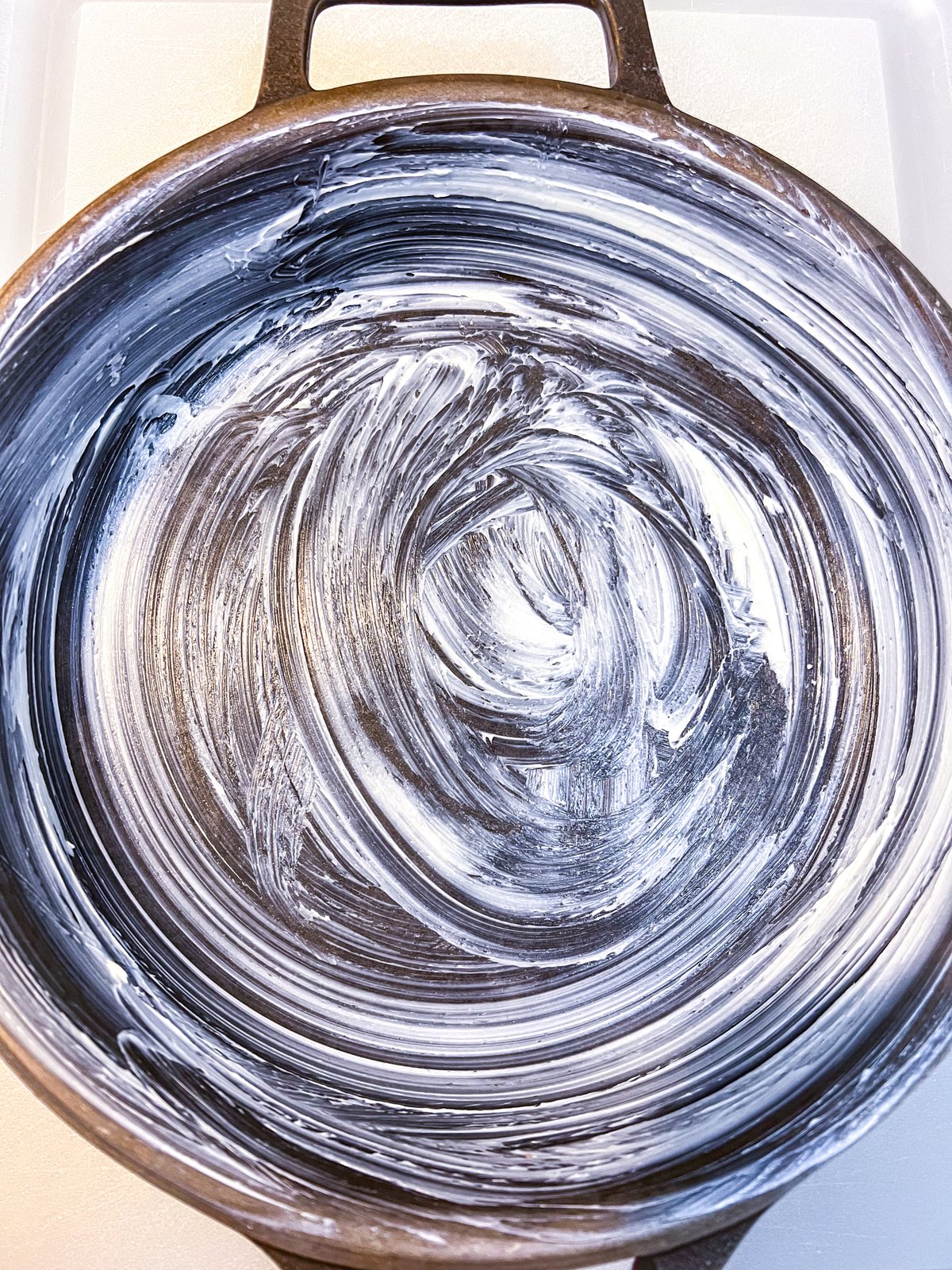 A cast iron skillet greased with butter for baking caramel brownies.