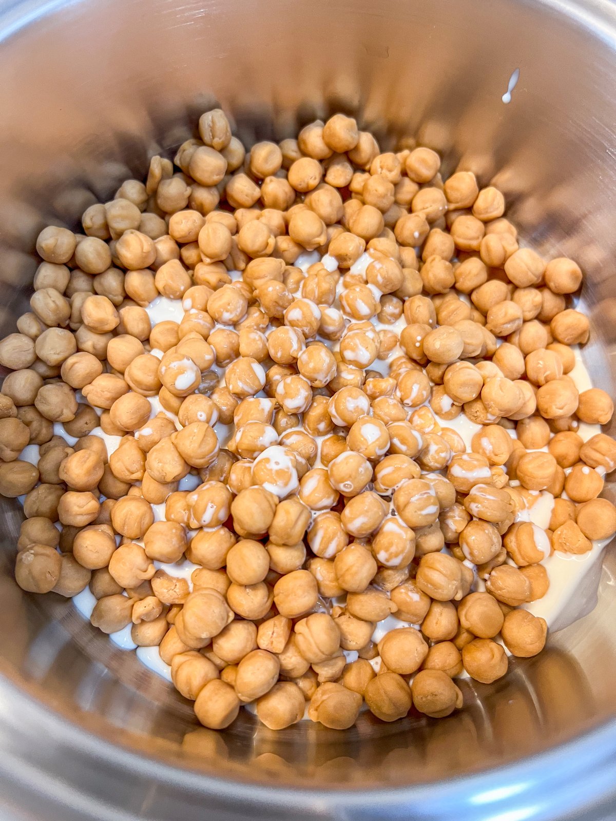 Caramel candies and evaporated milk melting in a saucepan.