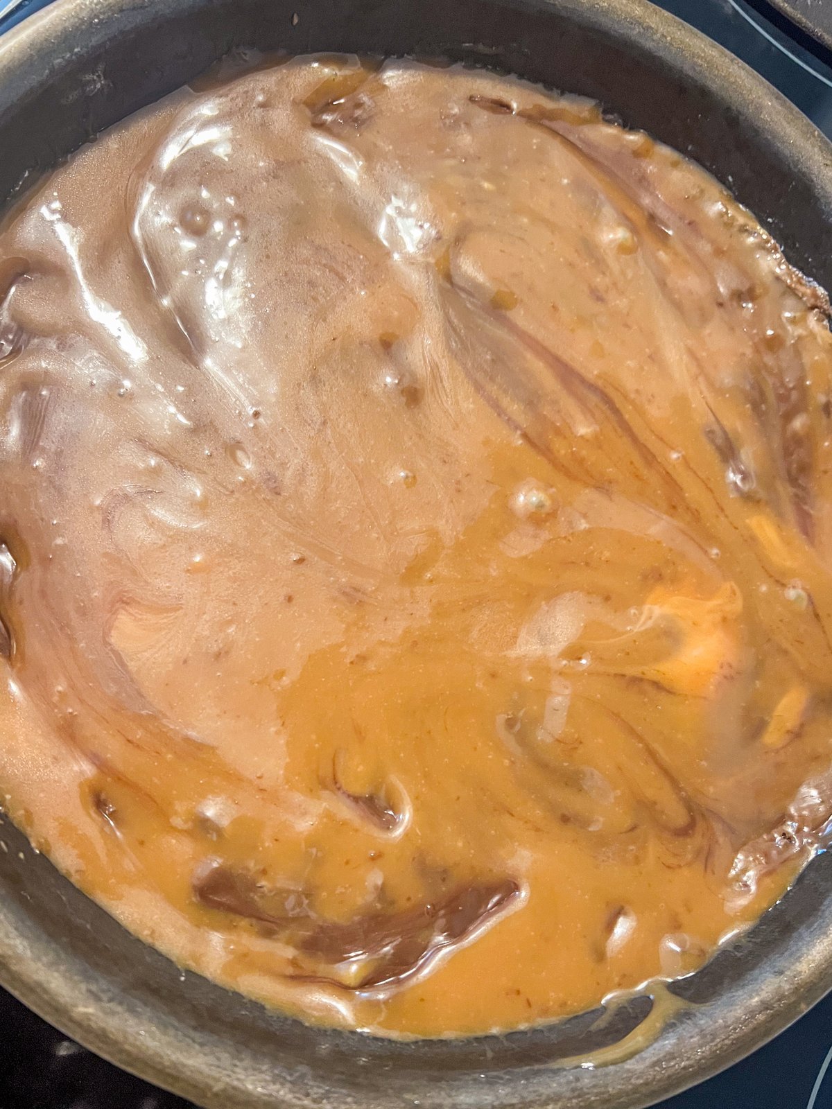 Caramel sauce poured over chocolate chips on the brownie layer.
