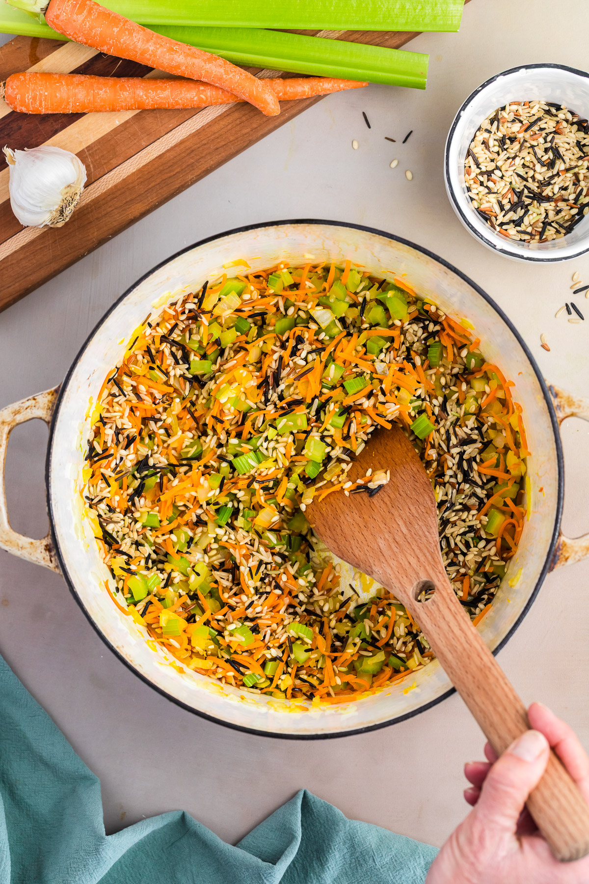 Wild rice added to sauteed vegetables in a dutch oven