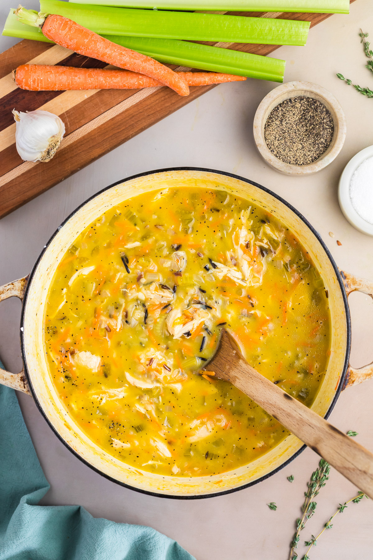 Finished chicken wild rice soup with shredded chicken, wild rice, and fresh thyme in a dutch oven